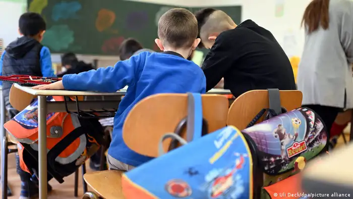 Children sit at school desks in a classroom