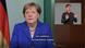 Frame do vídeo. Merkel aparece de blazer azul e colar. Ao lado direito, acima, há um quadro com um intérprete de libras. Frame do vídeo. Merkel aparece de blazer azul e colar. Ao lado direito, acima, há um quadro com um intérprete de libras.