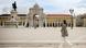 Woman wearing face mask walks by a large ornate building Woman wearing face mask walks by a large ornate building