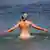 سيدة تسبح بدون ملابس في شاطئ خاص بالعراة في بحر البلطيق بألمانيا