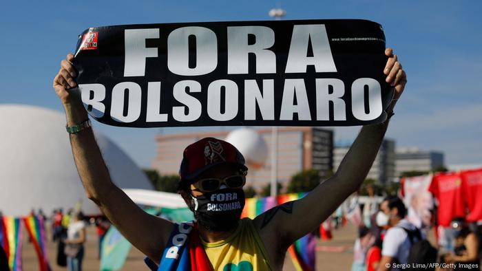 Homem mascarado ergue cartaz Fora Bolsonaro Homem mascarado ergue cartaz Fora Bolsonaro