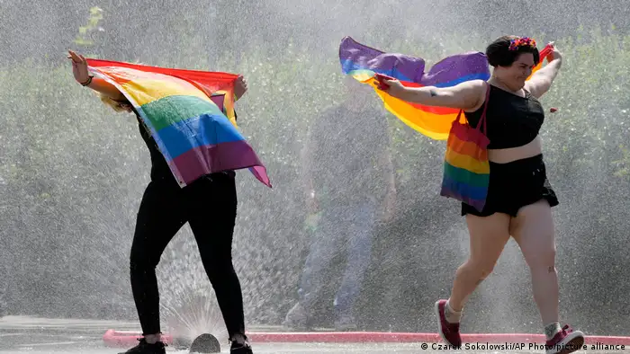 Two people with rainbow flags