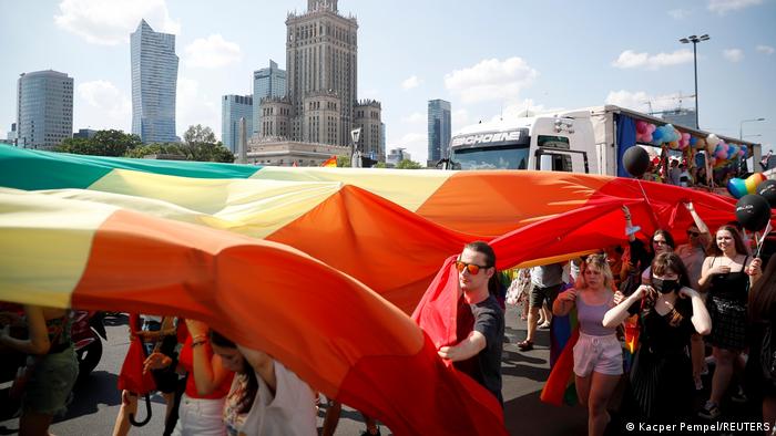 People carrying a rainbow banner at an 'Equality Parade' rally in Warsaw on June 19