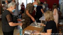 Armenians cast their ballots at a polling station during a parliamentary election in Yerevan, Armenia, Sunday, June 20, 2021. Armenians are voting in a national election after months of tensions over last year's defeat in fighting against Azerbaijan over the separatist region of Nagorno-Karabakh. (AP Photo/Sergei Grits)