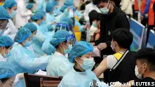 30.03.21 *** FILE PHOTO: Medical workers inoculate students with the vaccine against the coronavirus disease (COVID-19) at a university in Qingdao, Shandong province, China March 30, 2021. Picture taken March 30, 2021. China Daily via REUTERS ATTENTION EDITORS - THIS IMAGE WAS PROVIDED BY A THIRD PARTY. CHINA OUT./File Photo