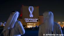 TOPSHOT - Qataris gather at the capital Doha's traditional Souq Waqif market as the official logo of the FIFA World Cup Qatar 2022 is projected on the front of a building on September 3, 2019. (Photo by - / AFP) (Photo credit should read -/AFP via Getty Images)