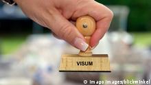 Stempel in der Hand mit der Aufschrift Visum, Deutschland stamp in a hand lettering Visum, visa, Germany BLWS549646 Copyright: xblickwinkel/McPHOTOx 