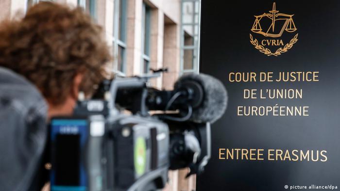 A cameraman films the sign at the entrance to the European Court of Justice