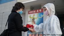 An audience member undergoes a health check as part of preventative measures against the Covid-19 coronavirus, before a performance by the North Korea's National Acrobatic Troupe at the Pyongyang Circus Theater as part of celebrations marking the annual Mother's Day public holiday, in Pyongyang on November 16, 2020. (Photo by KIM Won Jin / AFP) (Photo by KIM WON JIN/AFP via Getty Images)