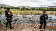 TOPSHOT - Colombian police officers stand guard at the trochas -illegal trails on the border between Colombia and Venezuela- near the Simon Bolivar international bridge, in Cucuta, Colombia, on October 14, 2020. (Photo by Schneyder MENDOZA / AFP) (Photo by SCHNEYDER MENDOZA/AFP via Getty Images)
