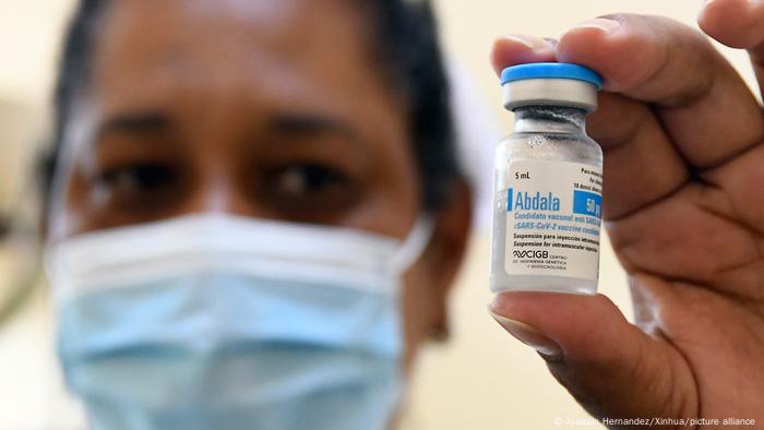 A nurse holds up a vial of vaccine