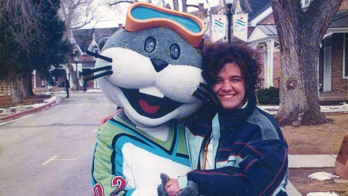 Sasha Kosanic hugging a mascot, smiling broadly into the camera