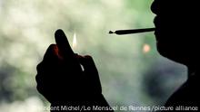 La sombra de un hombre fumando un cigarillo de marihuana.