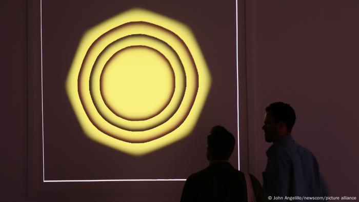 Two people look at the image of NFT Quantum by Kevin McCoy Two people look at the image of NFT Quantum by Kevin McCoy