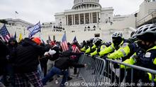 FILE - In this Jan. 6, 2021 file photo, rioters try to break through a police barrier at the Capitol in Washington. People charged in the attack on the U.S. Capitol left behind a trove of videos and messages that have helped federal authorities build cases. In nearly half of the more than 200 federal cases stemming from the attack, authorities have cited evidence that an insurrectionist appeared to have been inspired by conspiracy theories or extremist ideologies, according to an Associated Press review of court records. (AP Photo/Julio Cortez, File)