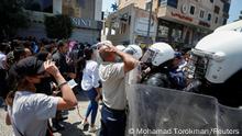 24.6.2021, Ramallah, West Bank, Demonstrators gather in front of police during a protest following the death of Nizar Banat, a Palestinian critic who died after being arrested by Palestinian Authority's security forces, in Ramallah in the Israeli-occupied West Bank, June 24, 2021. REUTERS/Mohamad Torokman