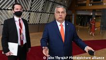 Hungary's Prime Minister Viktor Orban, right, talks to journalists as he arrives for an EU summit at the European Council building in Brussels, Thursday, June 24, 2021. At their summit in Brussels, EU leaders are set to take stock of coronavirus recovery plans, study ways to improve relations with Russia and Turkey, and insist on the need to develop migration partners with the countries of northern Africa, but a heated exchange over a new LGBT bill in Hungary is also likely. (John Thys, Pool Photo via AP)