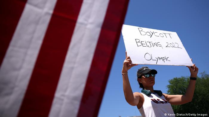 In Washington DC, a protester holds aloft a 'Boycott Beijing 2022 Olympics' sign