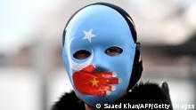 A protester wearing a face mask attends a demonstration in Sydney on June 23, 2021 to call on the Australian government to boycott the 2022 Beijing Winter Olympics over China's human rights record. (Photo by Saeed KHAN / AFP) (Photo by SAEED KHAN/AFP via Getty Images)