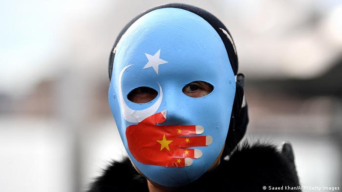 A protester wearing a face mask attends a demonstration in Sydney to call on the Australian government to boycott the 2022 Beijing Winter Olympics