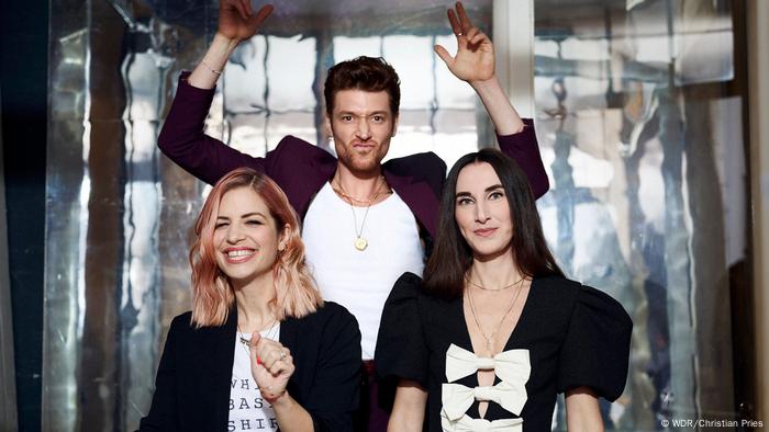 Daniel Donskoy raising his hands in the background, with Susan Sideropoulos and author Mirna Funk in front of him.