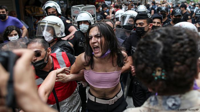 Turkish police restrain a protester with an arm lock