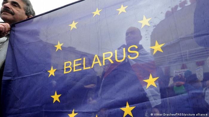 Синий флаг с желтыми звездами в расцветке ЕС, в центре которого надпись - Беларусь