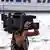A woman holding a television camera