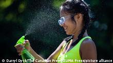 June 28, 2021, North Vancouver, BC, Canada: Leanne Opuyes uses a spray bottle to mist her face while cooling off in the frigid Lynn Creek water in North Vancouver, B.C., on Monday, June 28, 2021. Environment Canada warns the torrid heat wave that has settled over much of Western Canada won't lift for days, although parts of British Columbia and Yukon could see some relief sooner. (Credit Image: © Darryl Dyck/The Canadian Press via ZUMA Press