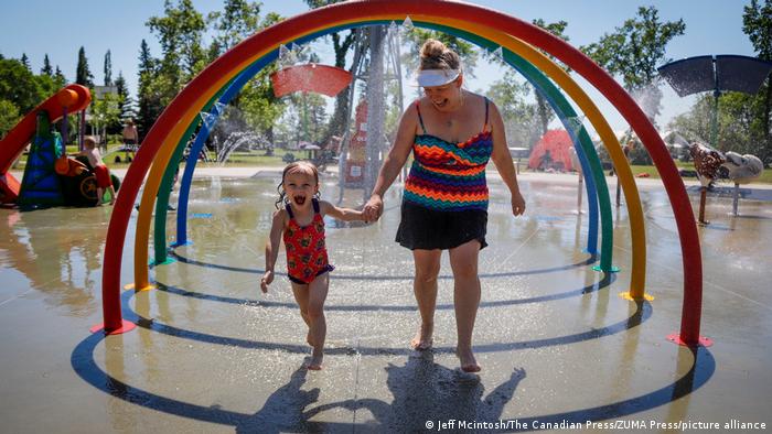 A girl and her mom run through a water park in Alberta on June 28