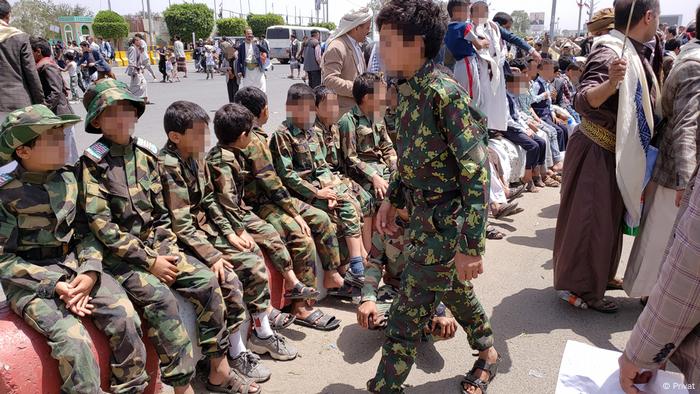 Children sit on a bench at a Houthi summer camp
