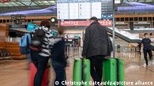 Reisende stehen vor einer Anzeigetafel im Terminal des Flughafens Berlin-Brandenburg (BER). Der Beginn der Sommerferien hat am Flughafen zu weniger Andrang geführt als erwartet. An den Check-in-Schaltern und an den Sicherheitskontrollen ging es am Donnerstagmorgen zügig voran.