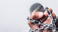 Hand holding microphone and have chain on fist hand on white background, Human rights day concept Copyright: xSorapopx Panthermedia27620825
