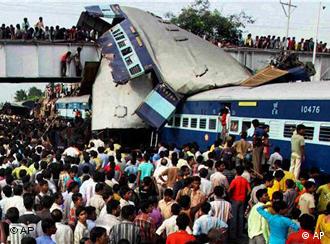Indians and rescue workers gather at the site of an accident at Sainthia station, about 125 miles (200 kilometers) north of Calcutta, India, Monday, July 19, 2010. A speeding express train collided with a passenger train at the station in eastern India early Monday, mangling the carriages and killing scores of people, railway police said. (AP Photo)