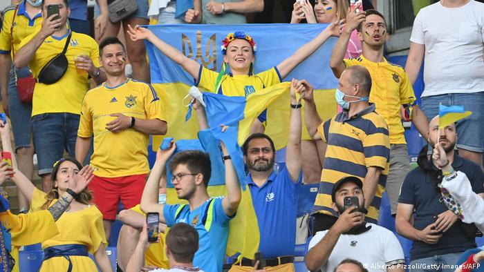 Ukrainian fans in yellow and blue national dress cheer in the stands at Ukraine's match against England.  This was the Euro 2020 quarter-finals. 