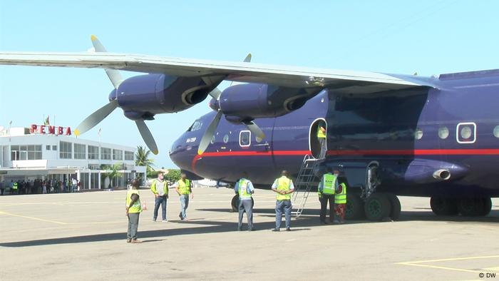 Workers unload a shipment of humanitarian aid from a large blue plane in Cabo Delgado