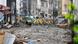 A street in Atami covered in mud, with yellow-clad rescue workers A street in Atami covered in mud, with yellow-clad rescue workers