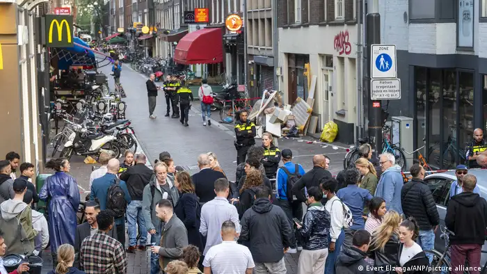 Crowd at the scene of the shooting of Peter R de Vries, with several police officers 