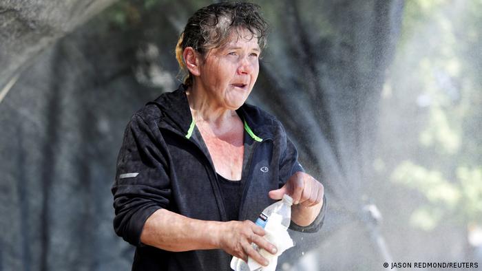 A woman experiencing homelessness cooling off during a heat wave in Washington, US