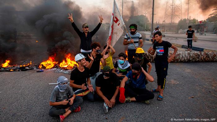 Demonstrators block a road during a protest in the southern city of Basra on July 14, 2020.