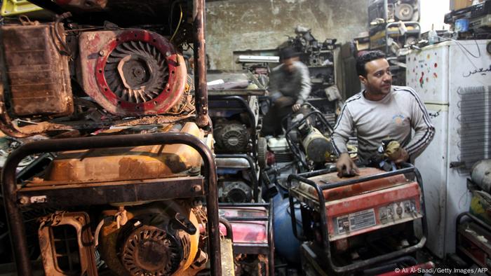 Iraqi men inspect diesel generators, which are often bought by individuals to supply electricity to their homes due to frequent power cuts