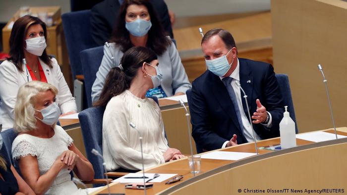 Social Democrat leader Stefan Lofven speaks to Marta Stenevi of the Green Party before a parliamentary vote