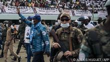 The President of the Central African Republic, Faustin Archange Touadéra (C), greets his supporters at the 20,000-seat stadium for an electoral rally, escorted by the presidential guard, Russian mercenaries, and Rwandan UN peacekeepers, in Bangui, on December 19, 2020. - One week before the first round of the presidential election, scheduled on December 27, 2020, the security situation is deteriorating rapidly and the United Nations Multidimensional Integrated Stabilization Mission in the Central African Republic (MINUSCA) is on high alert. (Photo by ALEXIS HUGUET / AFP)