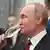 Russian President Vladimir Putin drinks champagne during a ceremony