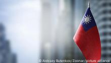 A small flag of Taiwan on the background of an urban abstract blurred background.