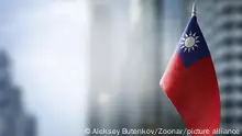 A small flag of Taiwan on the background of an urban abstract blurred background.