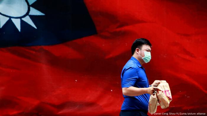 去年8月，杨智渊遭中国以“长期从事台独分裂活动、涉嫌危害国家安全”为由拘捕。图为台湾民众走过一面中华民国旗帜。（资料照）