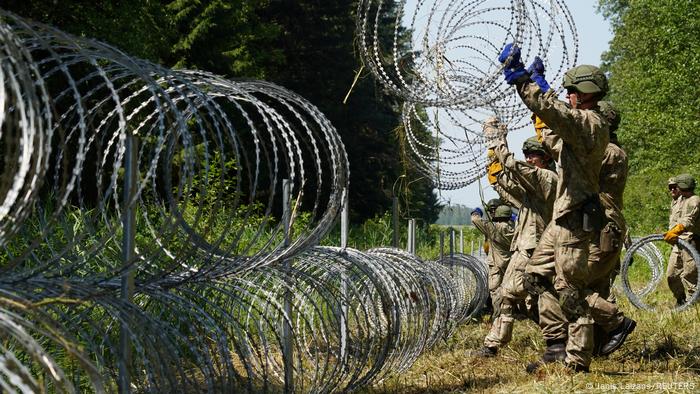 Des soldats lituaniens installent du fil de rasoir à la frontière