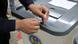 Two hands are seen holding a tool over a ballot box in Moldova Two hands are seen holding a tool over a ballot box in Moldova