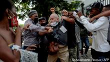 AP photographer, Spanish Ramon Espinosa, is attacked by the police while covering a demonstration against Cuban President Miguel Diaz-Canel in Havana, on July 11, 2021. - Thousands of Cubans took part in rare protests Sunday against the communist government, marching through a town chanting Down with the dictatorship and We want liberty. (Photo by Adalberto ROQUE / AFP)